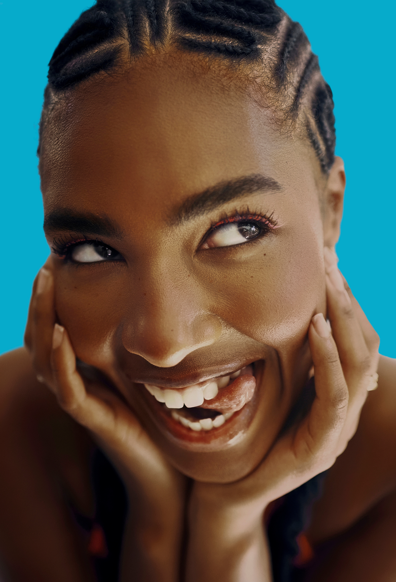 Close-up smile framed by fine cornrow braids